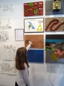 A young attendee interacts with the art, as Education Director Barbara Smtih Gioia watches