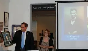 Anthony Czarnecki presenting a painting to Kendall Helbock, Outreach Coordinator, PCHS