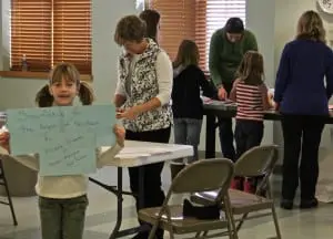 Kate Jordan holds up a sign for Newtown, Conn., at the North Highlands Firehouse, where Girl Scouts made snowflakes for Sandy Hook students, on Sunday, Dec. 29. Photo by Maggie Benmour