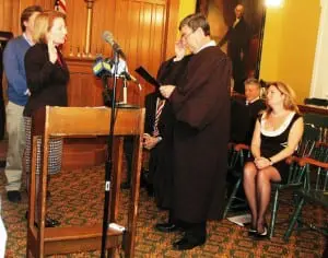 Barbara Scuccimarra takes her oath of office, surrounded by family and officials, including County Executive MaryEllen Odell, lower right. Photo by L.S. Armstrong