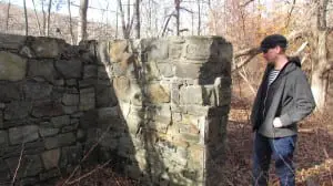 Kelly examines a structure that was once part of a rooming house for miners located along present-day Sunken Mine Road. Photo by M. Turton