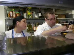 Afternoon garde manger Alessandra Benedetto and Chef Brandon Collins discuss preparations for roulade of guinea hen.
