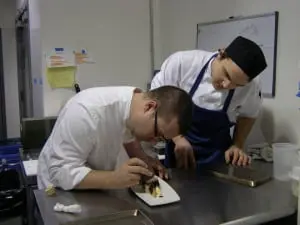 Swift Chef Brandon Collins, left, with evening garde manger Steven Hejnas, artfully creates a new menu addition.