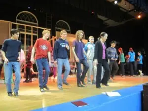 Choreographer Katie Bissinger works with the tapping cowboys on the final bows. Photo by A. Rooney