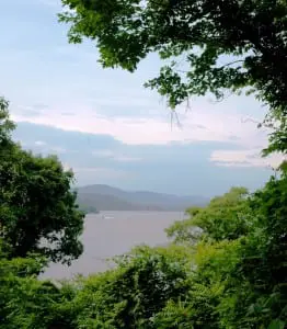 As twilight approaches, trees frame a view of the Hudson River at Mystery Point.