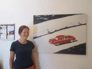 Catalyst Gallery's Erica Hauser, standing near one of her own paintings. Photo by A. Rooney.