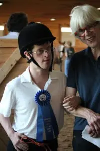 Therapeutic riding student Brett Edwards received a medal at last year's event. Volunteer Hope Platt accompanied him.