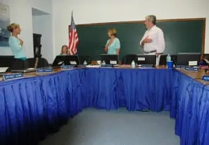 The Pledge of Allegiance heads the agenda at the GUFS meeting, with Superintendent Gloria Colucci, center left, and Board President Raymond O'Rourke, center right, joining in, alongside Board Member Theresa Orlandi, left, and a young flag-bearer. Photo by L.S. Armstrong