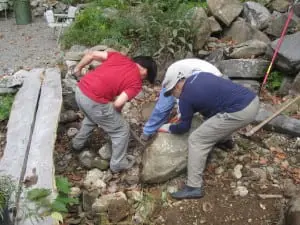 The back-breaking work of moving heavy boulders.