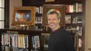 Tristan Elwell, pictured in front of two of his illustrations now on display at Butterfield Library. (Photo by A. Rooney)