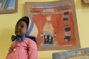 Children's art — like this depiction of the South Avenue School by one of its students — enhances library walls. (Photo by A. Rooney)