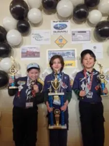 Jordan Albertson, Jude Columb and Gael Frezza stand in the Winner's Circle. Photo courtesy of Pack 137