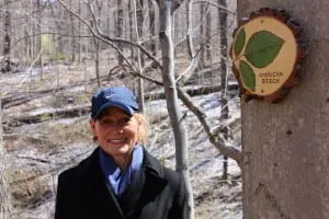 Stacey Farley, who created the new "discovery" plaques, near her American Beech marker.