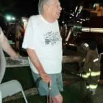 A stoic Dan Wright watches firefighters attacking the blaze in his home. Photo by L.S. Armstrong