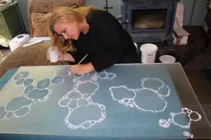 Carla Goldberg at work drawing on one of her "Seafoam" series. (Photo by A. Rooney)