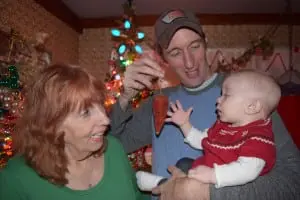 Eleven-month-old Shaylee Hamel, with her father Bob Hamel and her grandmother Carol Hamel, already seems fascinated by "the carrot." (Photo by M. Turton)