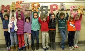 A group of Haldane second graders proudly holds the Makerspace sign.