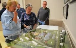 AttendeesâatâtheâpublicâhearingâonâtheâButterfieldâredevelopmentâdesignâstudyâaâmodelâofâtheâproposedâcomplex.