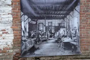 Skilledâ
carpentryâ
staffâ
membersâ
lookâ
outâ
fromâ
theirâ
workâ
benchesâ
inâ
aâ
19th-centuryâ
photoâ
displayedâ
atâ
theâ
oldâ
patternâ
shopâ
duringâ
aâ
recentâ
tourâ
ofâ
Scenicâ
Hudson'sâ
Westâ
Pointâ
Foundryâ
Preserve.