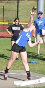 Catherine Parr competes in the shot put event in the league championships meet at Putnam Valley High School as teammate Sami Gosal and Coach John Stowell look on. (Photo by Peter Farrell)
