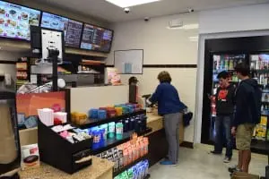 Customers line up inside Dunkin' Donuts. The former service station now also houses a convenience store.