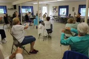 The seniors work with weights during fitness class.