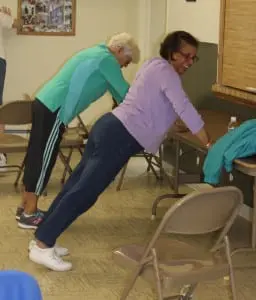 Push-ups, tailored for seniors by using tables and walls, are done each session during fitness for seniors class.