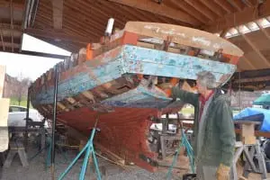 Jim Kricker, director of the Riverport Wooden Boat School, explains repairs being made to the Woody Guthrie (Photo by Michael Turton) 