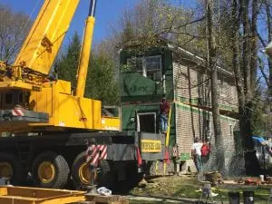 The Santos family, who lost their Parrott Street home to a fire nearly a year ago, had their new, modular home crane-lifted onto the site this week. (Photo by A. Rooney)
