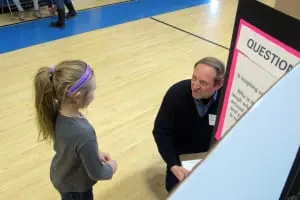 Chip Marks, a volunteer judge, assesses an elementary student's presentation on laughter (photo provided) 
