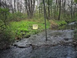 Silver Stream flowing under the fence from Stewart International Airport on its way to Lake Washington in Newburgh. (Photo by B. Cronin)