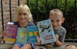 Josephine and Henry Foley-Hedlund show a few of the dozens of books they took out of the Butterfield Library in one day. (Photo by A. Peltonen)