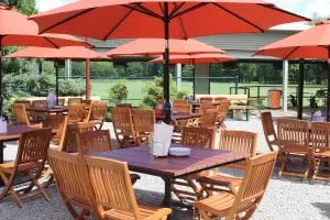 Six-seat outdoor tables combine with larger, communal ones in Yankee BBQ's large al fresco dining area.  (Photo by A. Rooney)