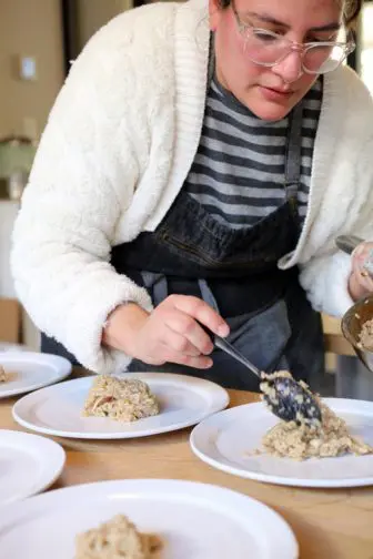 Reyes plating a dish at a pop-up event