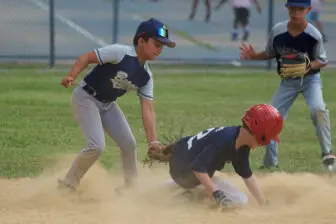 Shortstop Gavin Justice tags a runner out at second on Wednesday; the 11U team earned its first win of the summer.
