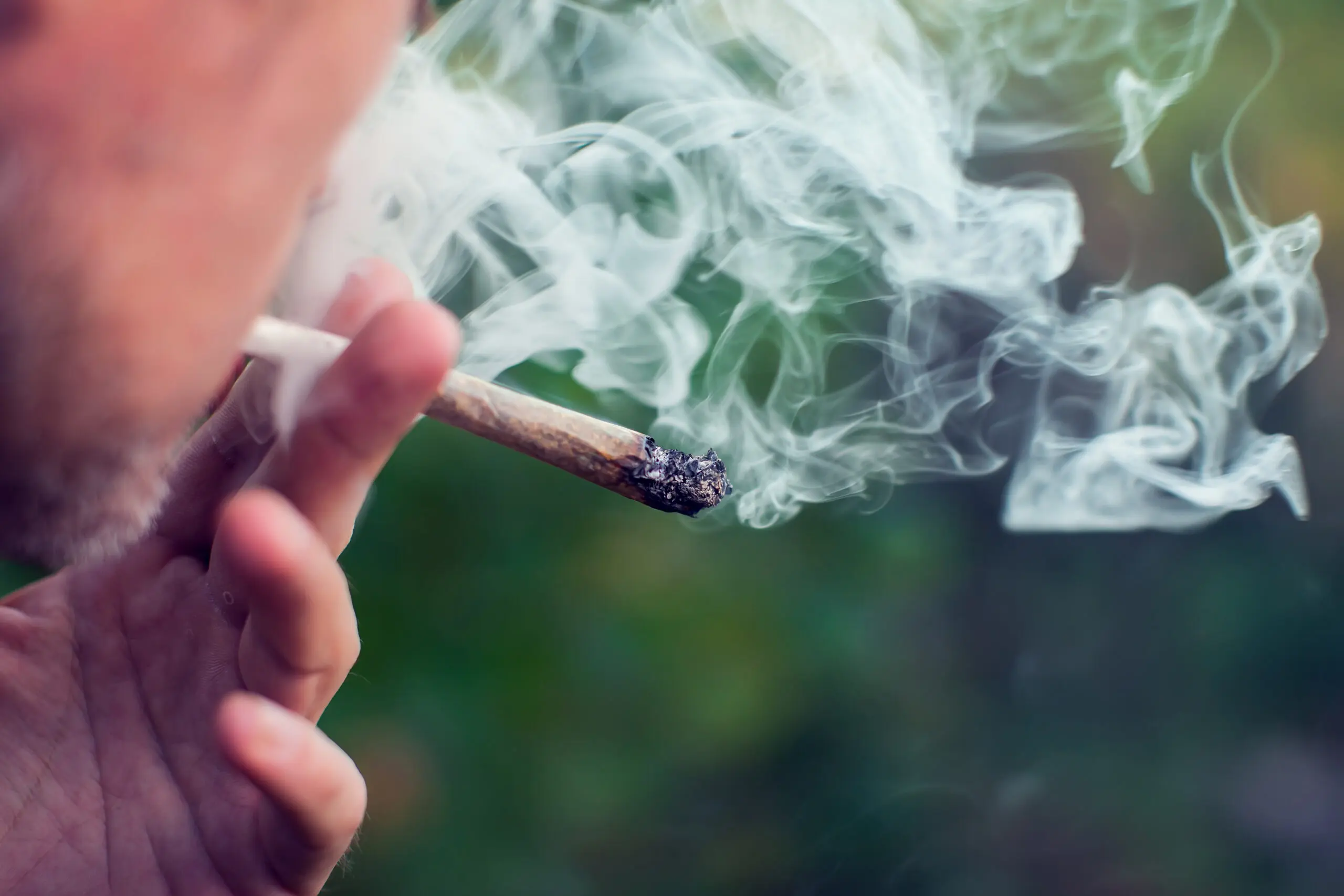 Man smokes a joint. Medical marijuana use and legalization of the cannabis, light drugs concept