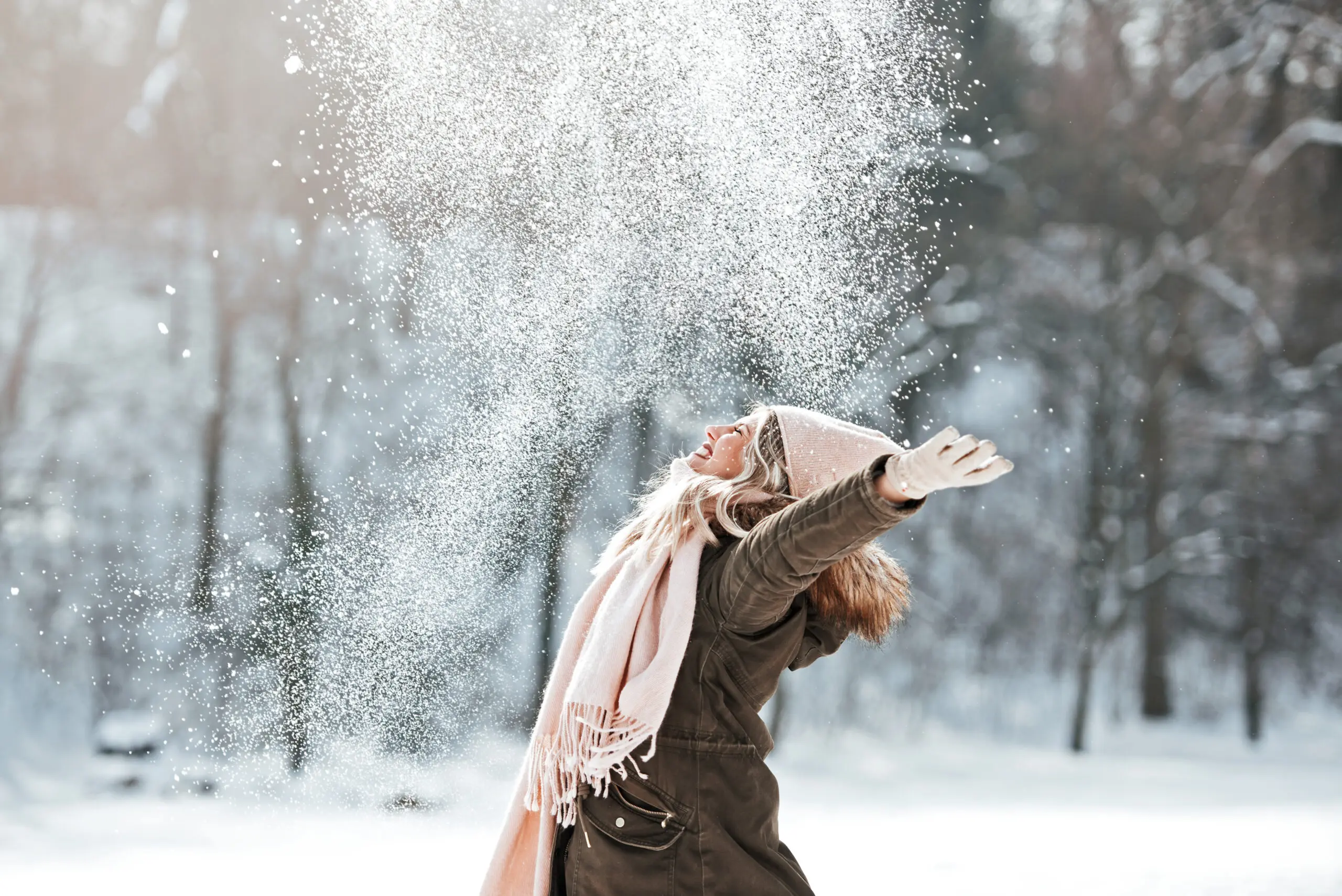 Beautiful young woman enjoying in the snow
