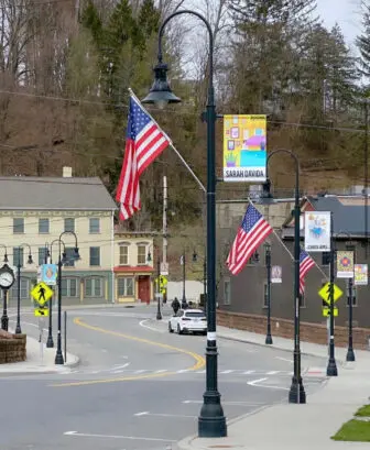 Banners featuring the work of Sarah Davida, Chris Ams and others artists overlook a roadway in the Village of Wappingers Falls.