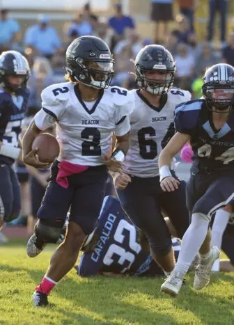 Beacon quarterback Jazziah Whitted (2) looks for room against Saugerties after a block by Kevin Beal (64).
