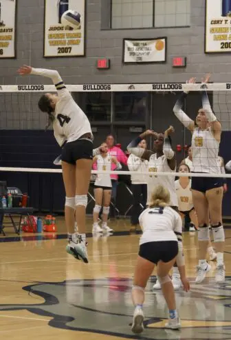 Daveya Rodriquez (4) prepares for a spike against Lourdes. No. 3 is Evy Diebboll.