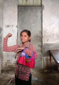 A girl in Nepal poses with a sports bra she received from the project.Photo provided