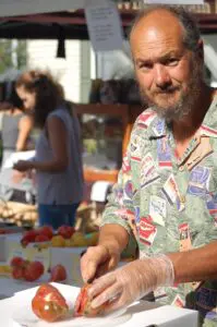 Jay Armour slices samples of heirloom tomatoes at the Cold Spring Farmers' Market