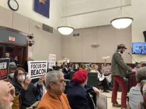 During the public comment, audience members held signs indicating their positions on the resolution. Photo by J. Simms
