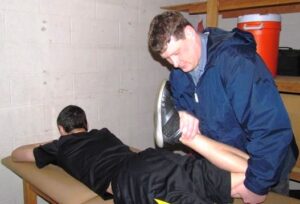 Shane Osgood does some stretching with a Haldane athlete