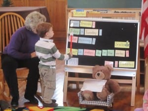 St. Philip's Nursery School Director Joanne Chadwick and a partner point out the word 'Today' during circle time, while Cuddles the bear assists. Photo by A. Rooney