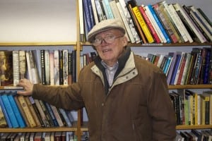 Frank Volkmann stands before his soon-to-disappear bookshelves. Photo by K.E. Foley