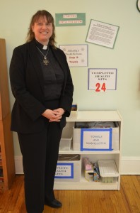 Rev. Margaret Laemmel by the health-kit station in the hall of the United Methodist Church of Cold Spring