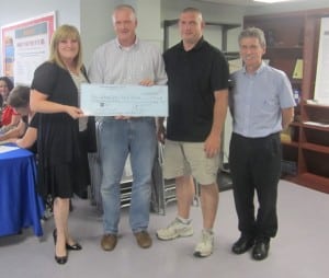 Dan Hughes, president of the Haldane Blue Devil Booster Club, presents a check to board members, left to right, Gillian Thorpe, Jon Champlin and Peter Henderson. Photo by A. Rooney