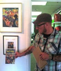 Taste Like Chicken and Short Walls Gallery owner Matt Held holds up Batman 'zine cover to artist Joel F. Naprstek's original watercolor sketch and final acrylic painting. Photo by Sommer Hixson