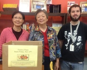 Howland Public Library staff, from left, Ethel Lee, Ai-Ping Ma, and Richard Jewell welcome Food for Fines donations to benefit the New Vision Church Food Pantry at the Beacon Community Resource Center. (Photo courtesy of HPL)